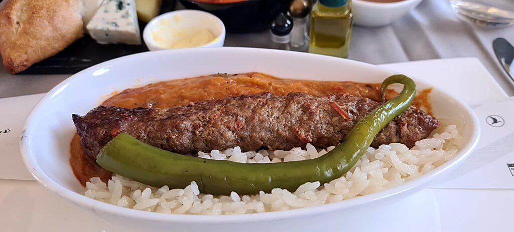 Adana kebab with roasted vegetables and rice